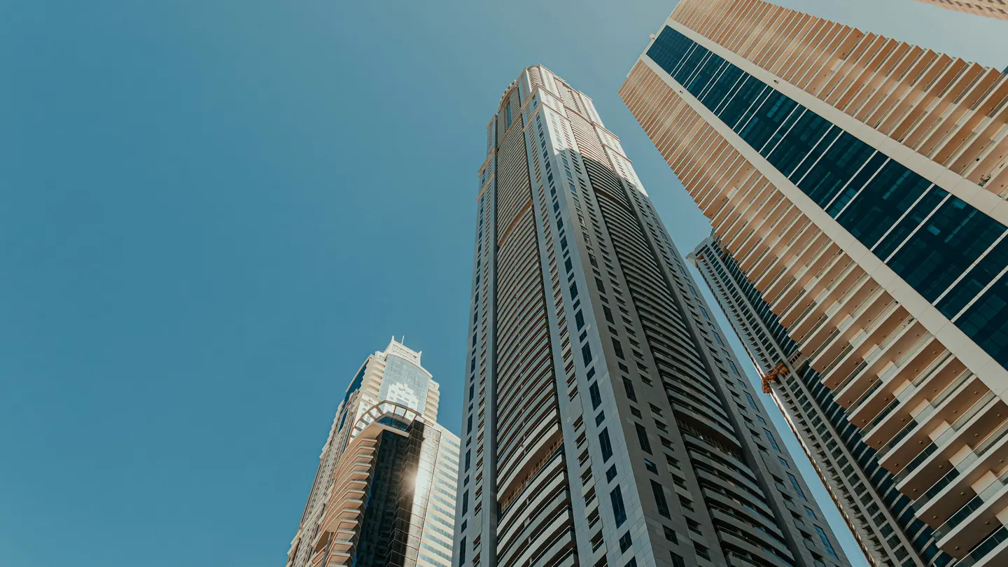 Residential towers seen from below with a palm tree