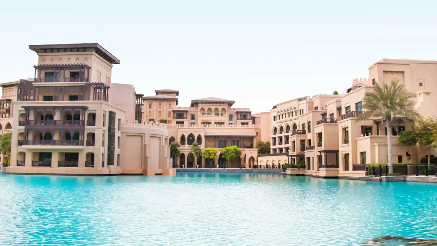 Low-rise sand-coloured residential buildings around a pool
