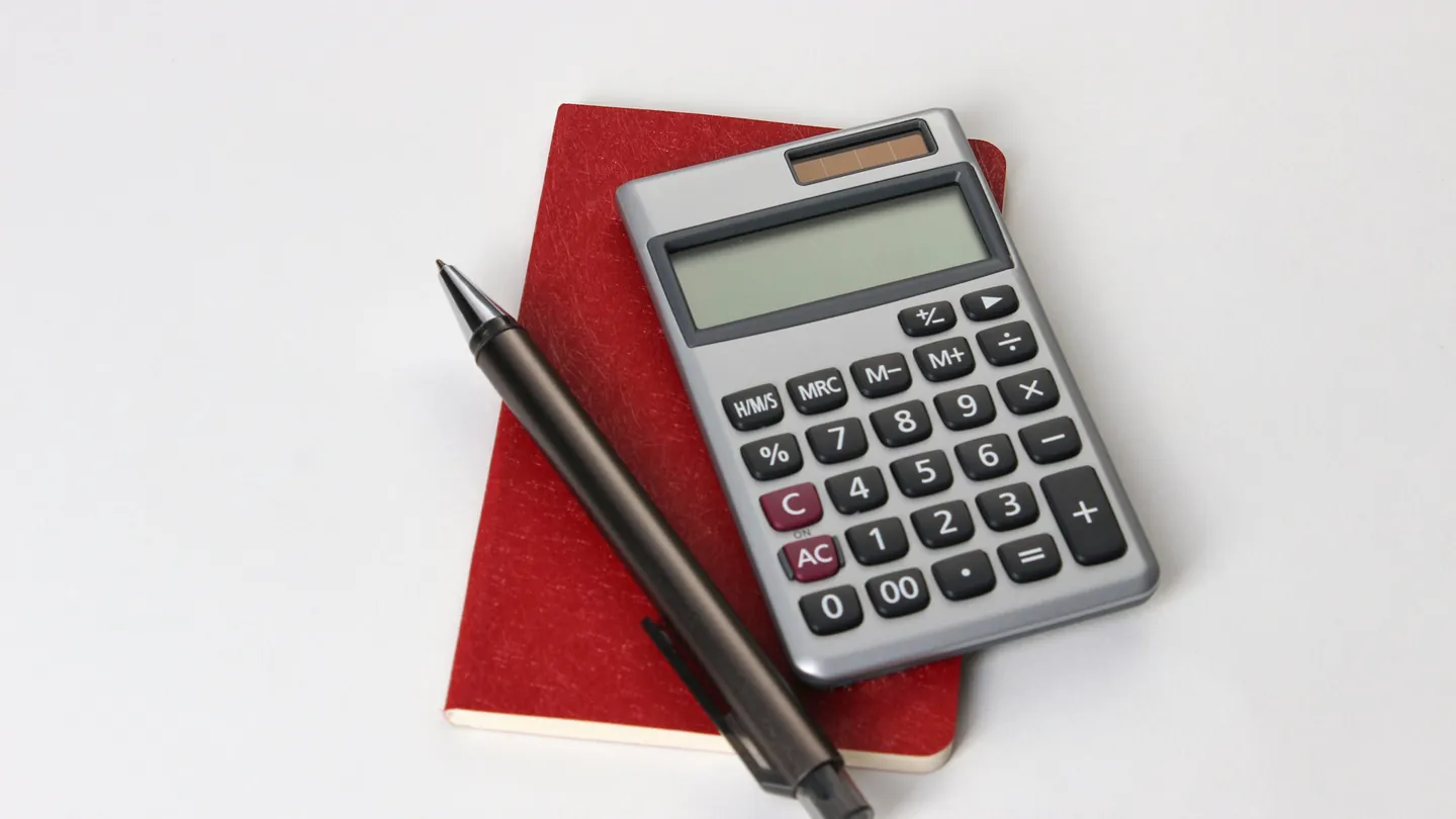 Calculatrice et stylo sur un carnet