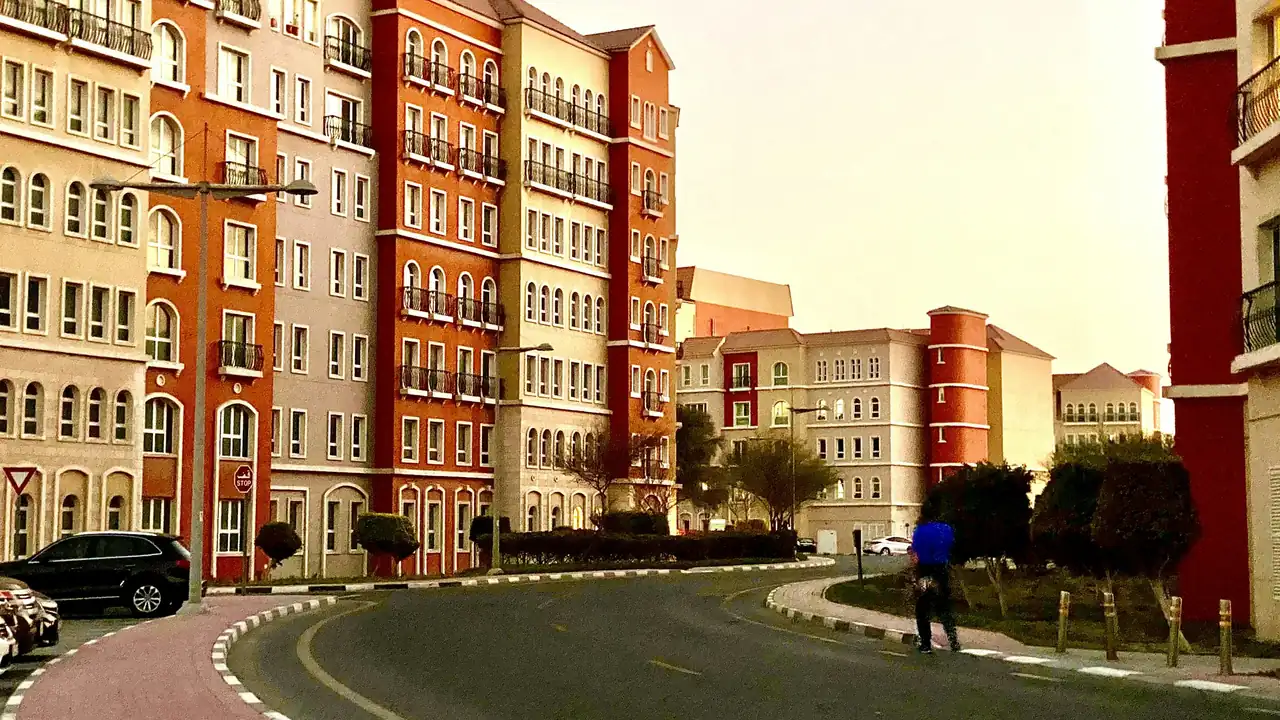 Low-rise apartment buildings and a street with people walking in Dubai