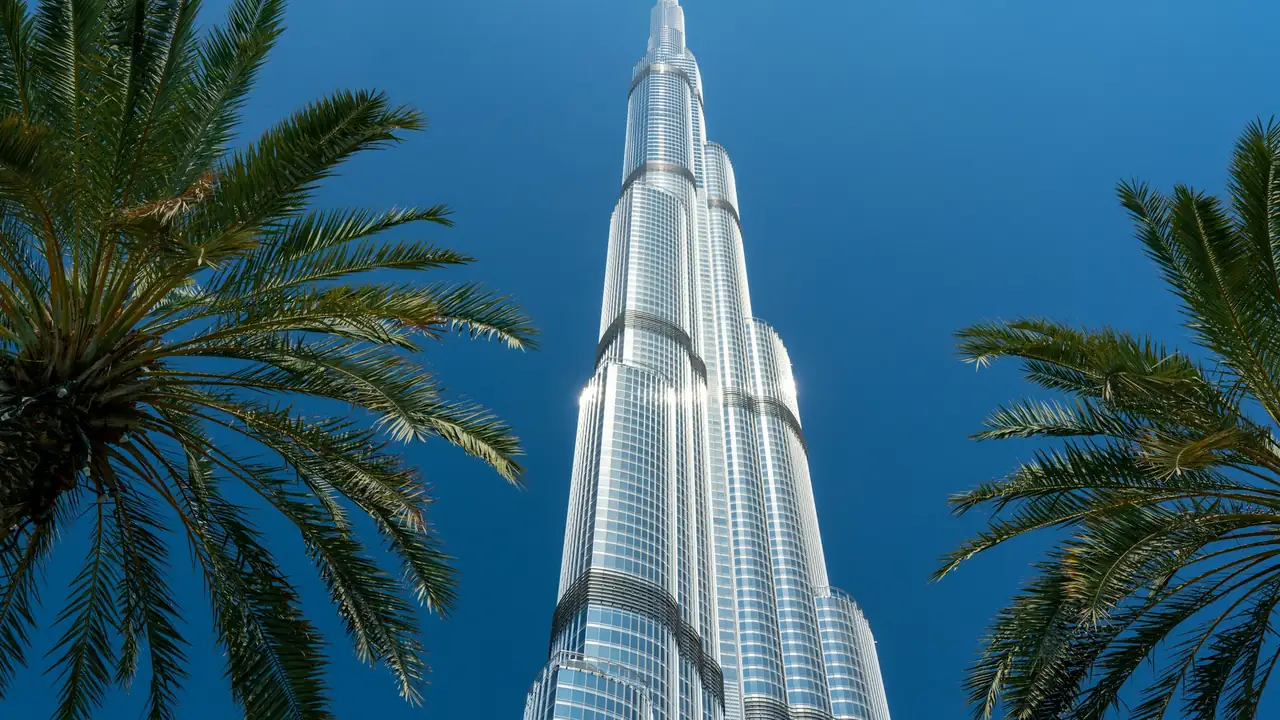 Burj Khalifa spire between palm trees