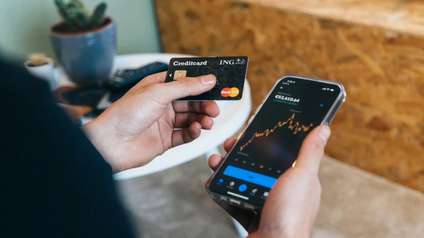 Smartphone e carta bancaria in mano