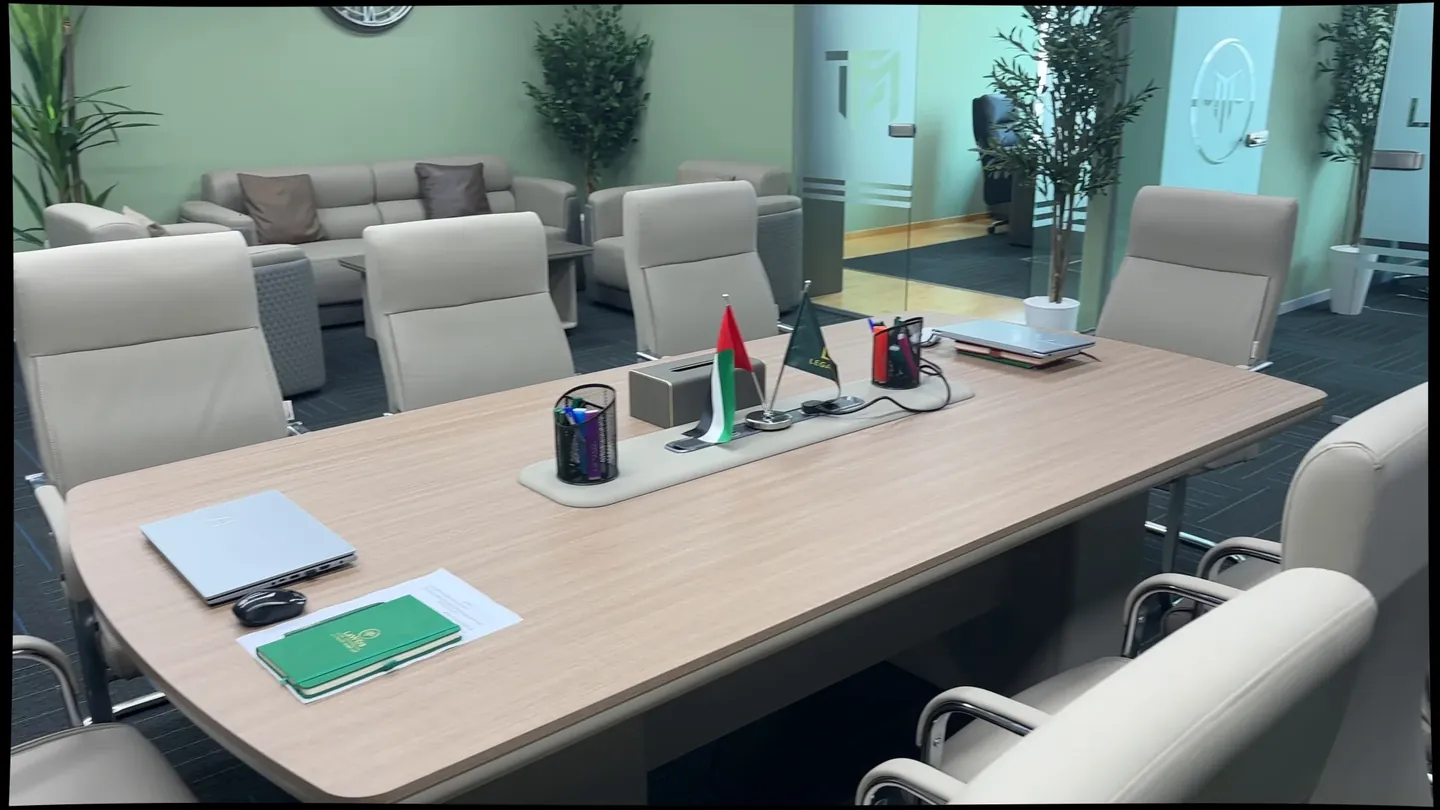 Meeting-room table with a laptop and a notebook before a meeting