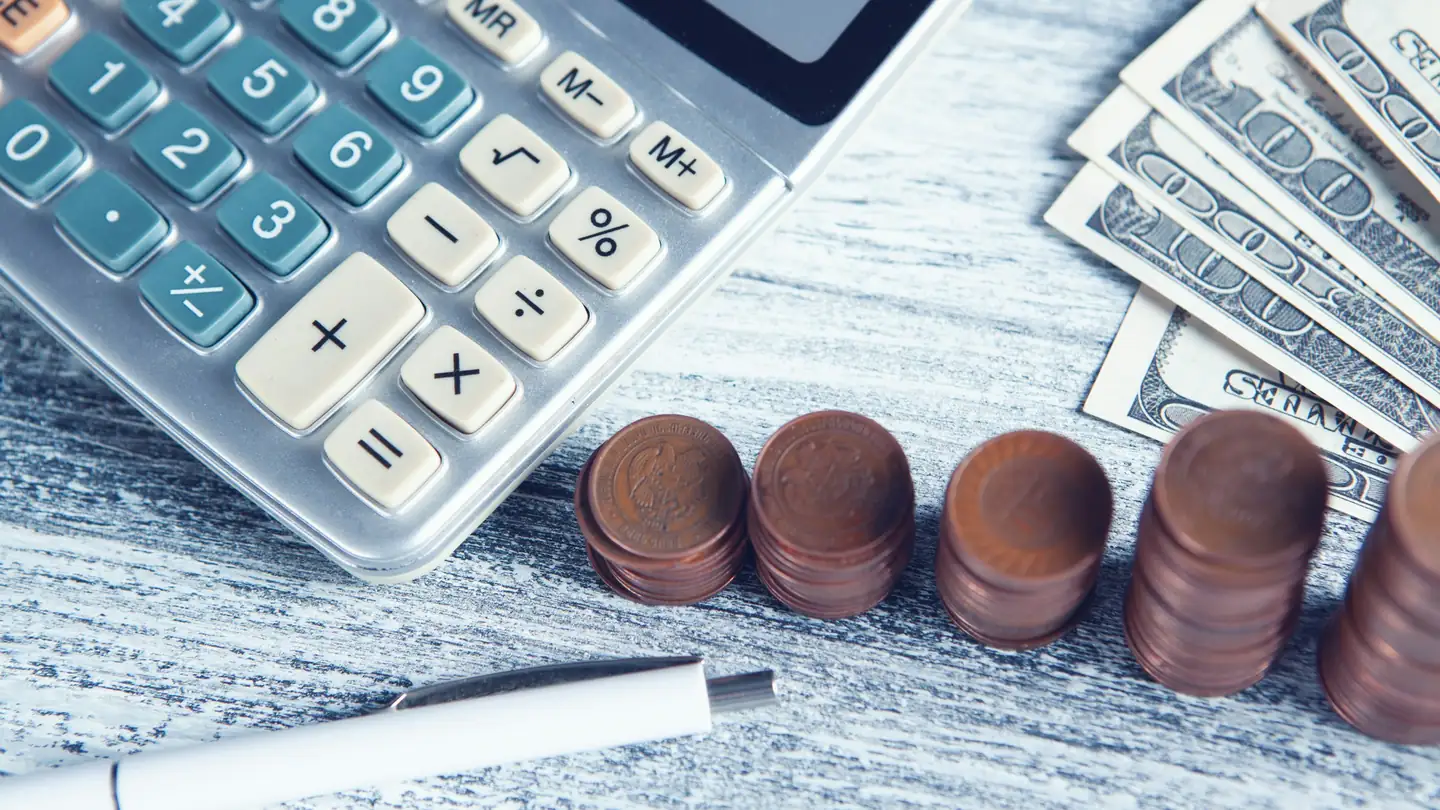 Calculatrice, stylo et pièces de monnaie