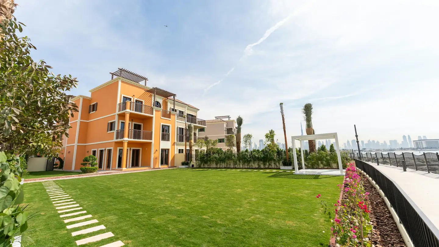 A low-rise residential building next to a green lawn
