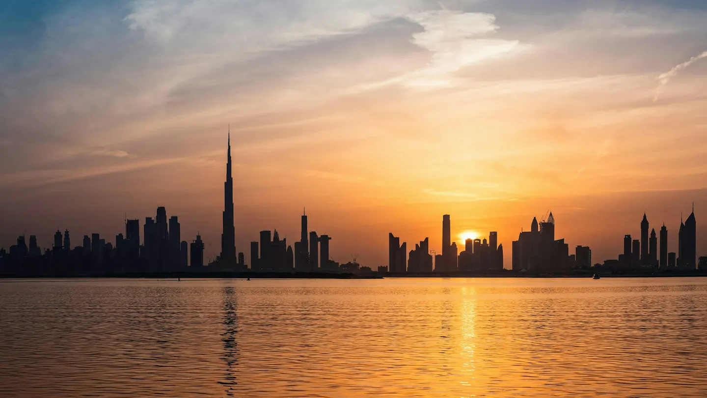 Dubai skyline with Burj Khalifa at sunset over the water