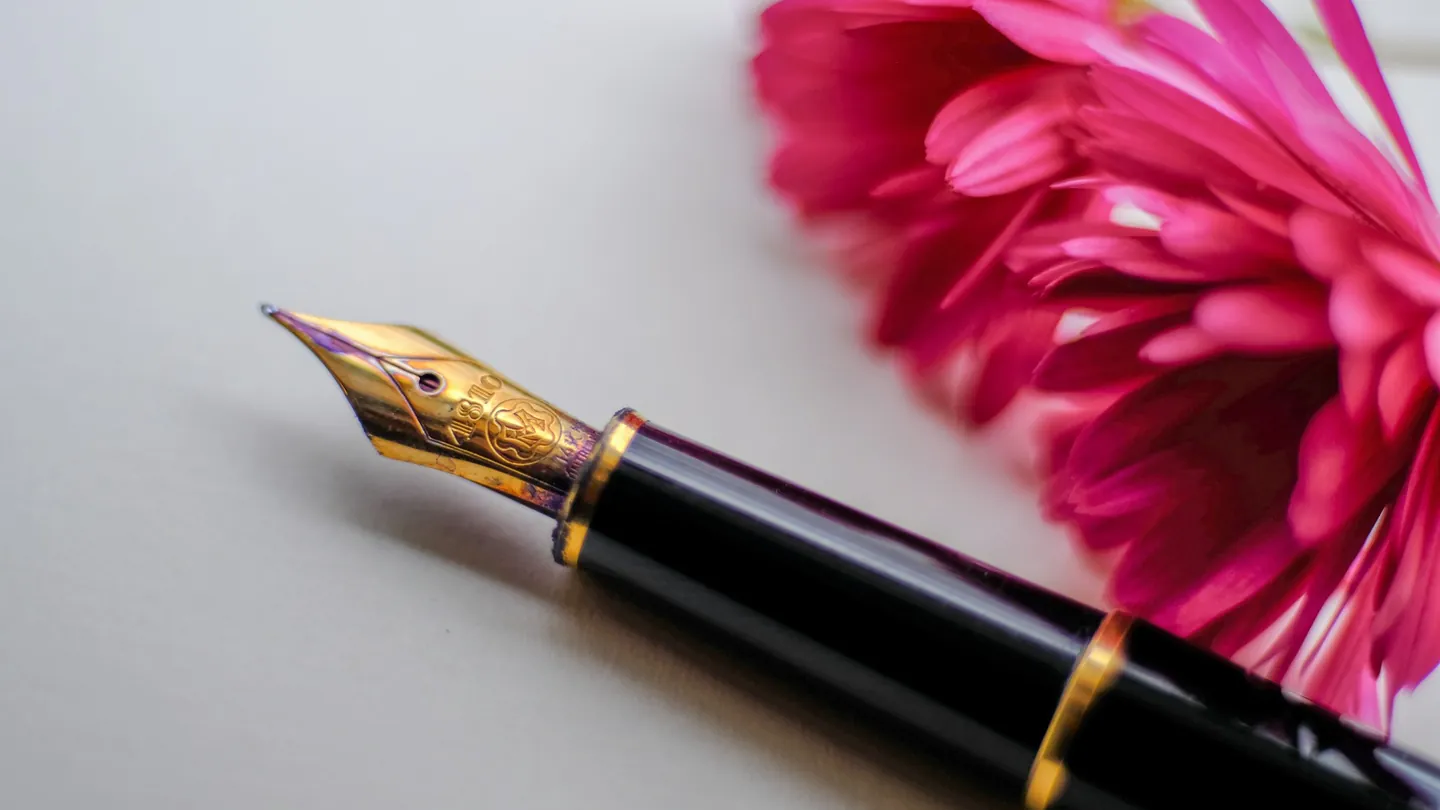 Stylo-plume et une fleur sur un bureau